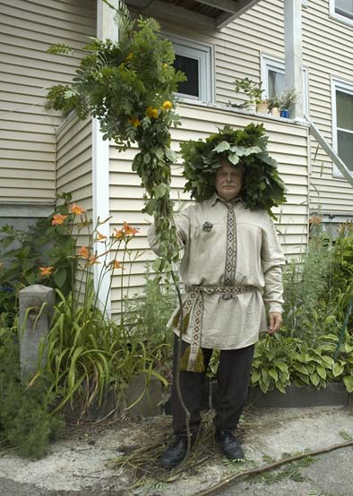 Jonas Stundzia wearing a head garland made of oak leaves and holding a kupole staff, Lithuanian summer solstice garlands, 2012; Jonas Stundzia; Lawrence, Massachusetts; Photography by Maggie Holtzberg